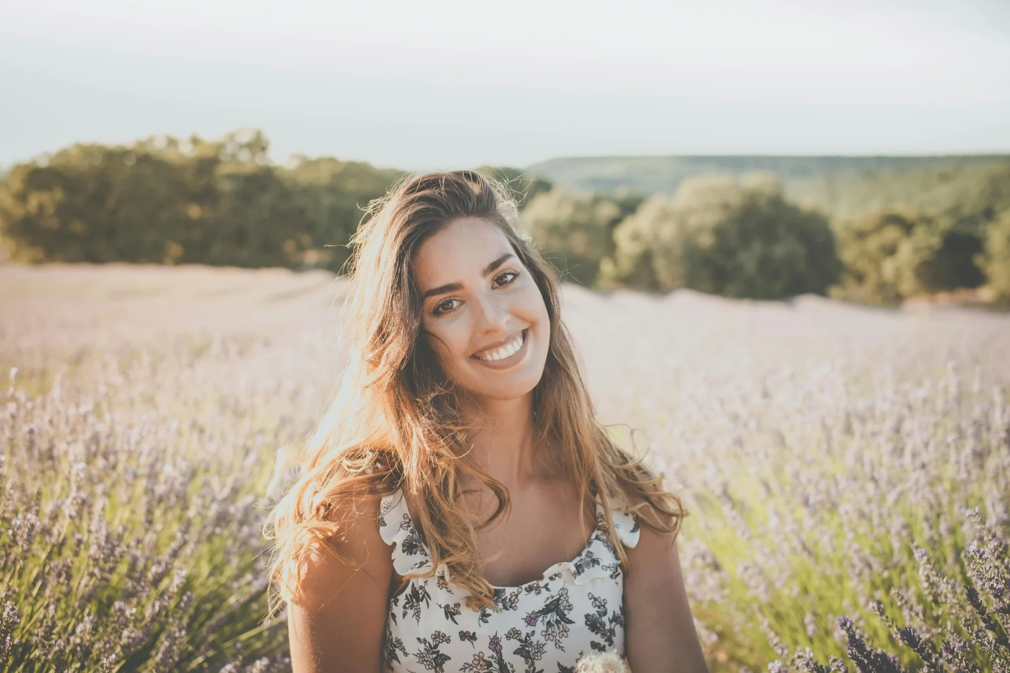 Femme rayonnante souriant dans un champ de lavande