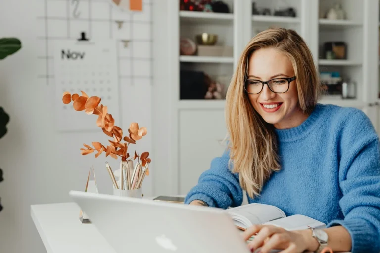 Femme souriant devant son ordinateur portable